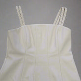 White strapless top with braided straps on a tiled floor